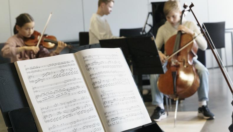 Nuotteja nuottitelineellä ja pianotrio