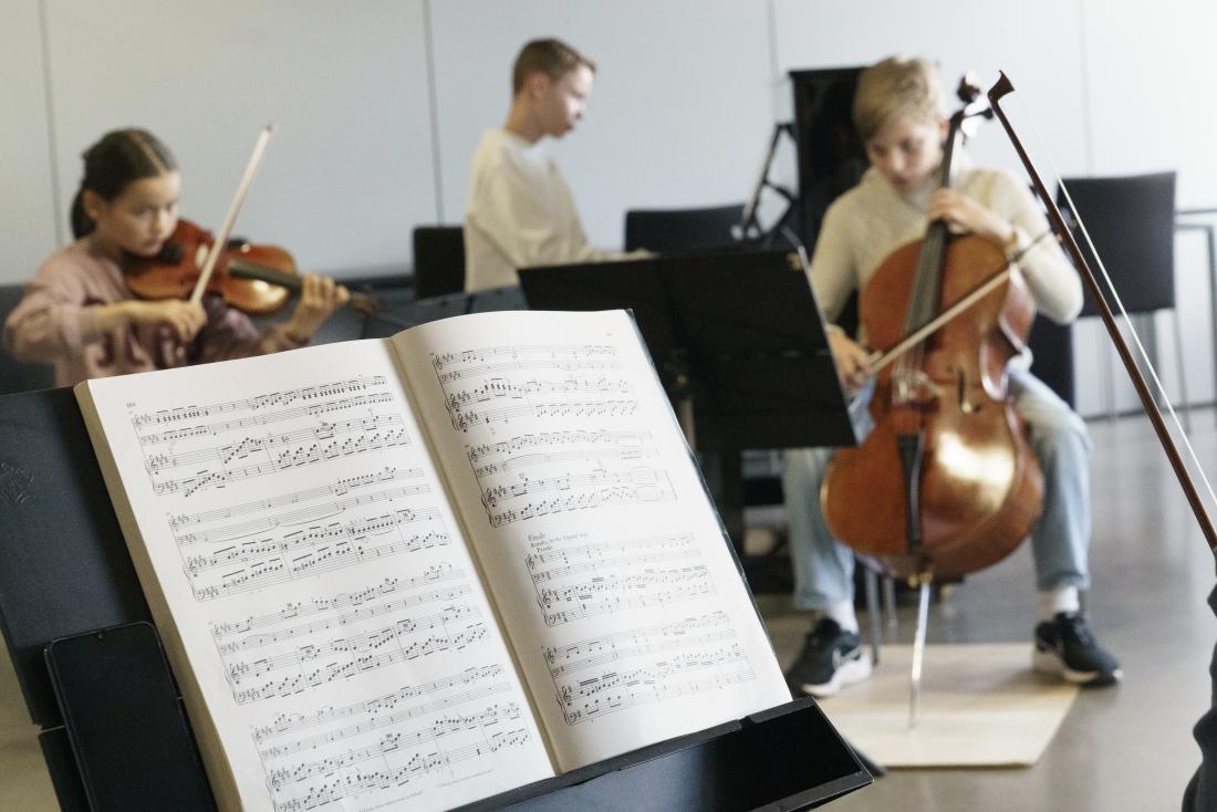 Nuotteja nuottitelineellä ja pianotrio