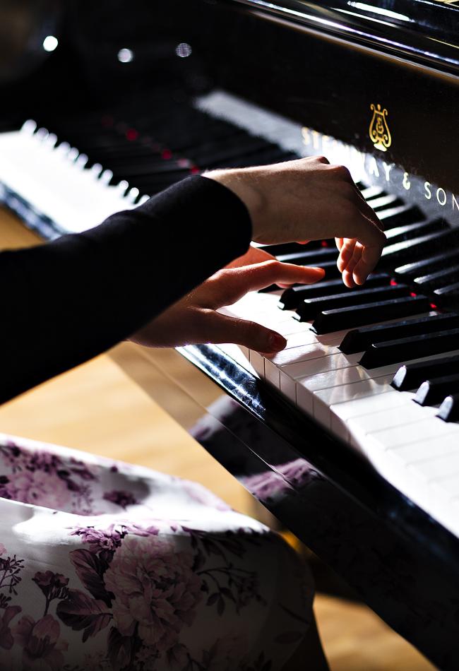 Close-up photo of a pianist's hands on the keys.